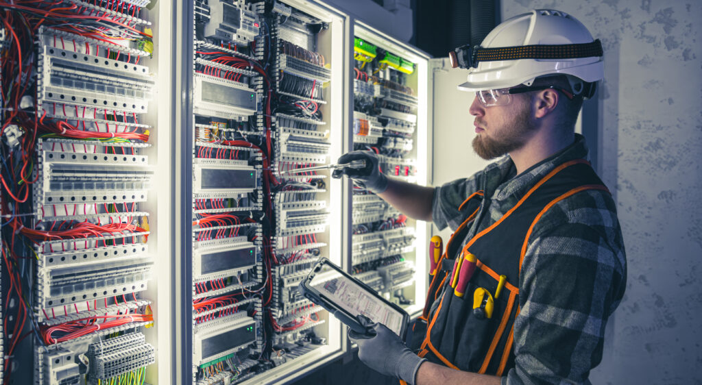 electrician overalls focused work switchboard with fuses using tablet